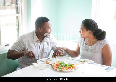 Smiling couple eating together at table Stock Photo