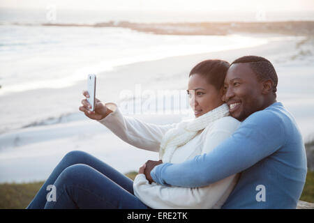 Smiling couple taking cell phone selfie at beach Stock Photo