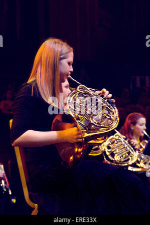 Female French horn player playing in a youth symphony orchestra at one of the Schools Prom series of concerts at the Royal Stock Photo