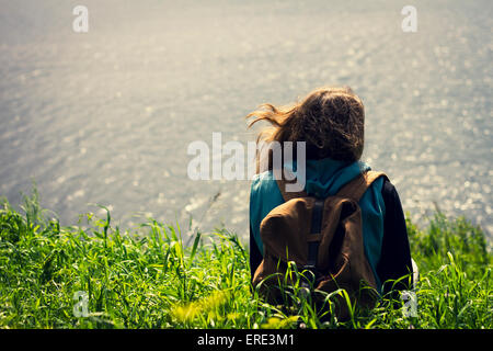 Caucasian woman laying in grass near lake Stock Photo
