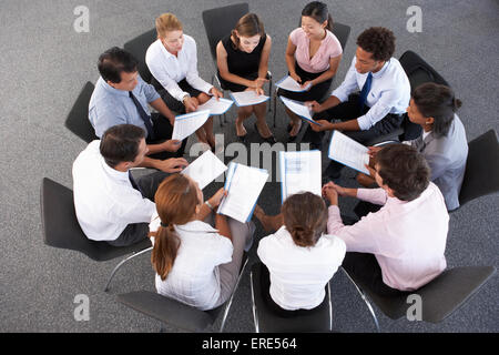 Overhead View Of Businesspeople Seated In Circle At Company Seminar Stock Photo