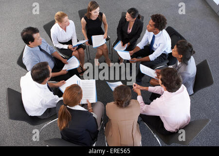 Overhead View Of Businesspeople Seated In Circle At Company Seminar Stock Photo