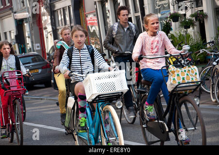 Family riding bikes in Amsterdam streets Stock Photo