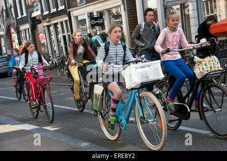 Family riding bikes in Amsterdam streets Stock Photo