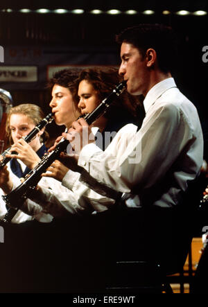 Boys playing clarinet in youth orchestra alll wearing same shirts Stock Photo