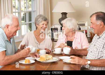 Group Of Senior Couples Enjoying Afternoon Tea Together At Home Stock Photo