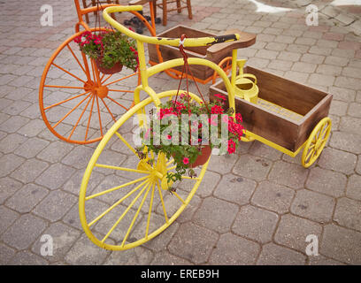 Ornamental penny farthing tricycles planters, with trugs on display in Fethiye's old town, Turkey. Stock Photo