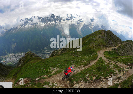 A mountain biker rides a trail high above the town of Chamonix in the French Alps. Stock Photo