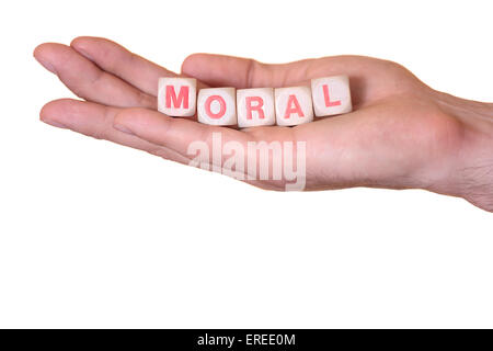 The word moral written with wooden dice on the he palm of the hand. Isolated on white background Stock Photo