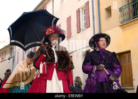 Two ladies in Victorian costumes taking part in a Valentine's Day parade in the village of Roquemaure, Southern France. Stock Photo