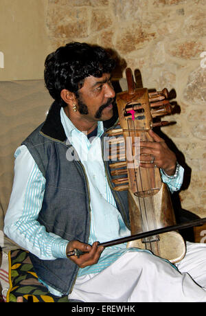 Indian singer and sarangi player performing in a private setting.  The sarangi is the most important instrument in the folk Stock Photo