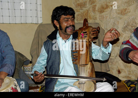 Indian singer and sarangi player performing in a private setting.  The sarangi is the most important instrument in the folk Stock Photo