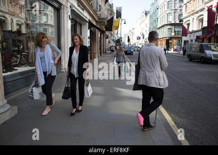 Man with a pink leg cast on New Bond Street, London, UK. Stock Photo