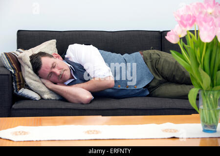 handsome businessman in his 50's sleeping on couch Stock Photo