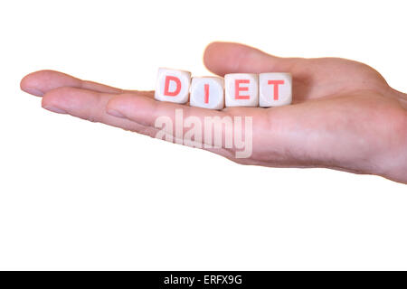 The word diet written with wooden dice on the he palm of the hand. Isolated on white background Stock Photo