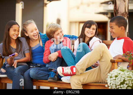 Group Of Children Sitting On Bench In Park Together Stock Photo - Alamy