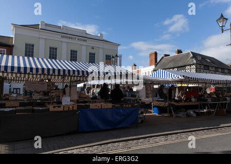 Market in Ludlow market square in Ludlow in Shropshire with the Assembly Hall building in the distance Stock Photo