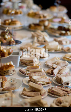 A table of sandwiches and cakes during afternoon tea. Stock Photo