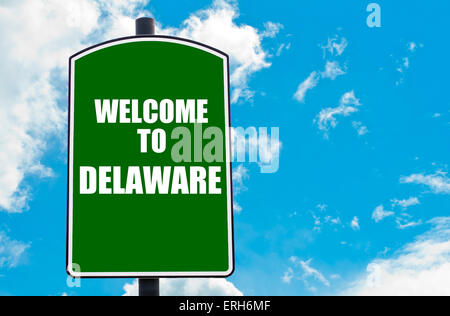 Green road sign with greeting message Welcome to DELAWARE isolated over clear blue sky background with available copy space. Stock Photo