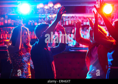 Energetic friends dancing in night club Stock Photo