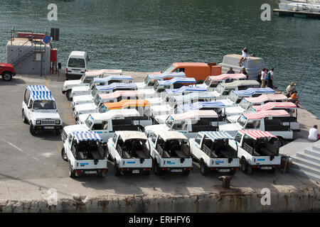 24 Maruti Suzuki Gypsy off road tour vehicles wait on the quayside of Mgarr harbour Gozo for the next group of tourists. Stock Photo