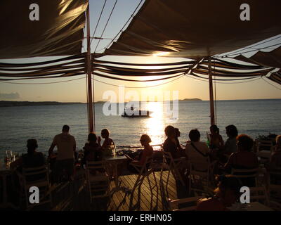 Friends watching the sun set outside cafe mambo Ibiza Stock Photo