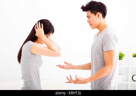 Angry young couple arguing in living room Stock Photo