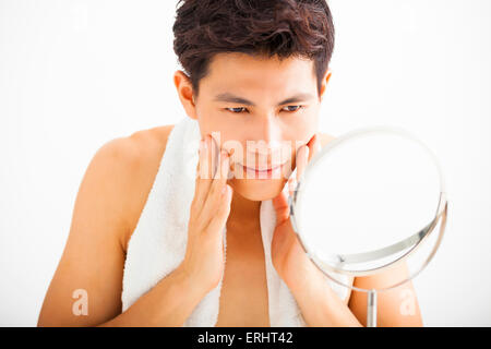 Young  man touching his smooth face after shaving Stock Photo