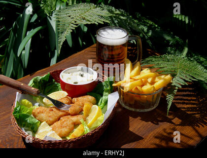 Scampi and chips in a basket, salad,Ta Ta sauce and a cool beer Stock Photo