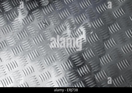 Dark gray shining metal floor surface with industrial diamond plate relief pattern Stock Photo