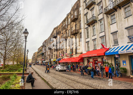 Historic buildings, shops and restaurants in the River Street along the broad Savannah River with many walking people. Stock Photo