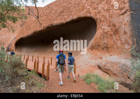 Australia, NT, Uluru - Kata Tjuta National Park. Uluru aka Aires Rock. Tourists with head nets in front of rock formation. Stock Photo