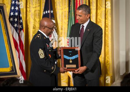 U.S. President Barack Obama awards the Medal of Honor to Command Sergeant Major Louis Wilson of the New York National Guard, accepting on behalf of the late Army Private Henry Johnson, for actions while serving in France during World War I, during a ceremony in the East Room of the White House June 2, 2015 in Washington, DC. Obama awarded the medal to two war heroes whose acts went unrewarded in their lifetime, because of discrimination. Stock Photo