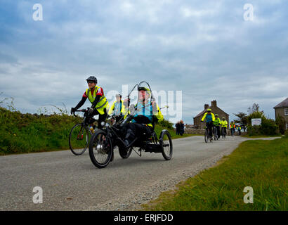 Cyclists taking part in a sponsored charity bike ride in Anglesey North Wales UK with racing bikes and a three wheel cycle Stock Photo