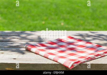 Empty wooden garden table with tablecloth with green bokeh background Stock Photo