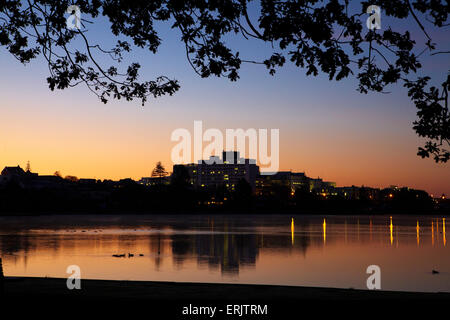 Waikato Hospital reflected in Lake Rotoroa at dawn, Hamilton, Waikato, North Island, New Zealand Stock Photo