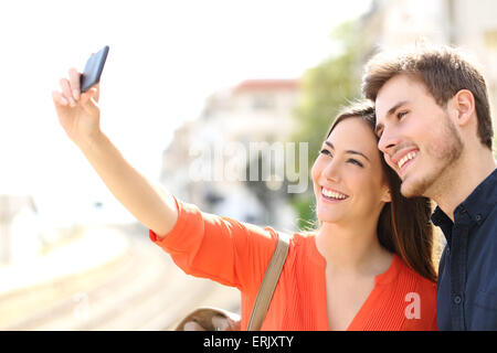Traveler tourists couple photographing a selfie in a train station Stock Photo