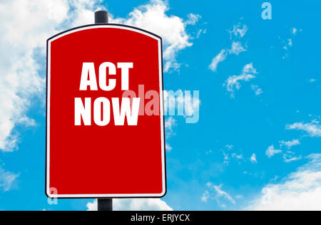 Act Now motivational quote written on red road sign isolated over clear blue sky background. Concept  image with available copy Stock Photo