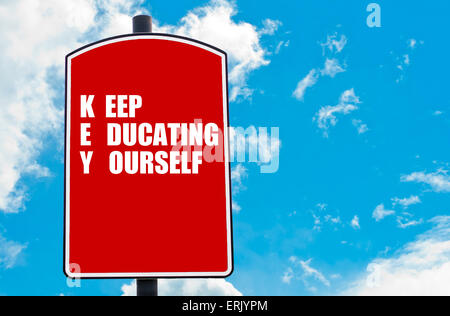 Keep Educating Yourself motivational quote written on red road sign isolated over clear blue sky background. Stock Photo
