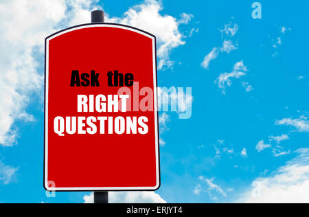 Ask The Right Questions motivational quote written on red road sign isolated over clear blue sky background. Stock Photo