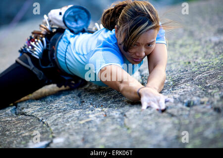 High angle perspective of an a woman climbing on a granite wall. Stock Photo