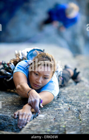 High angle perspective of an a woman climbing on a granite wall. Stock Photo