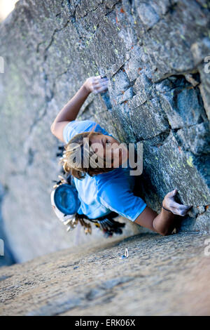 High angle perspective of an a woman climbing on a granite wall. Stock Photo