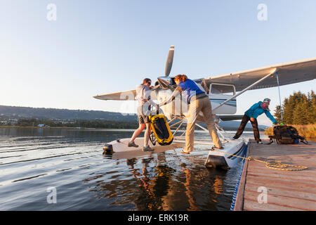 People unloading gear from a floatplane at a dock in Homer, Kachemak Bay State Park, Southcentral Alaska. Stock Photo