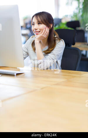 Young woman using computer in office Stock Photo