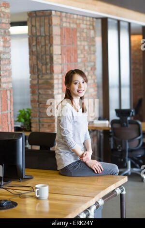 Young woman sitting in office Stock Photo