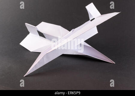Two white paper airplanes crashing in flight on a black background Stock Photo