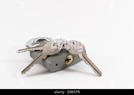 Single grey locked padlock with three silver keys Stock Photo
