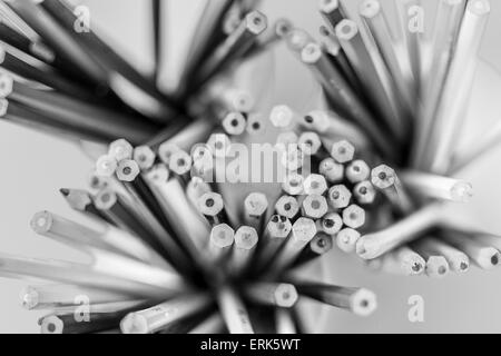 Overhead view of multicolored coloring pencils in pots in black and white Stock Photo