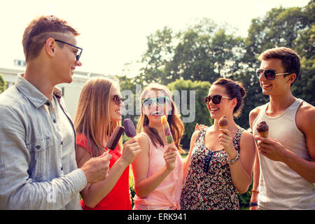 group of smiling friends with ice cream outdoors Stock Photo